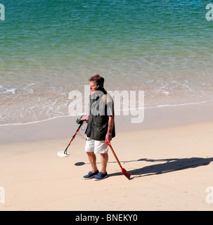 Un uomo con un rivelatore di metalli sulla spiaggia, England, Regno Unito Foto Stock