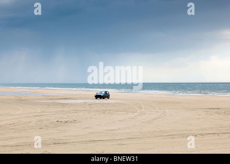 Auto in esecuzione sulla spiaggia con vista oceano in background Foto Stock