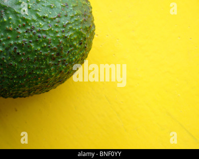 Frutto di avocado (Persea americana) su una tabella di colore giallo in Guatemala Foto Stock