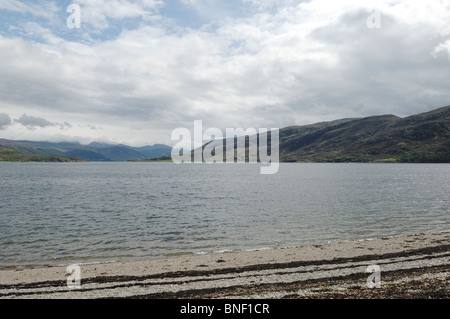 La spiaggia di ciottoli e lavato fino le alghe a Ullapool sulle rive di Loch scopa in Ross and Cromarty Highlands della Scozia Foto Stock