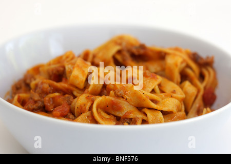 Autentica sana in italiano o in stile mediterraneo Tagliatelle alla bolognese Pasta servita in una ciotola con il n. di persone contro uno sfondo bianco Foto Stock