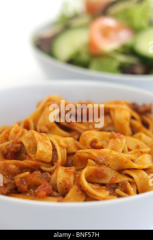 Autentica sana in italiano o in stile mediterraneo Tagliatelle alla bolognese Pasta servita in una ciotola con il n. di persone contro uno sfondo bianco Foto Stock
