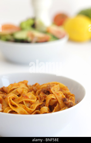 Autentica sana in italiano o in stile mediterraneo Tagliatelle alla bolognese Pasta servita in una ciotola con il n. di persone contro uno sfondo bianco Foto Stock