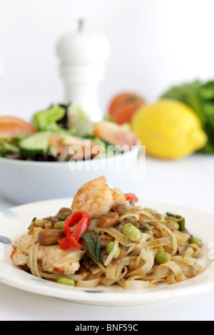 Autentico stile Thailandia Street Food Stir-Fried Pad Thai Noodles con pollo e gamberi contro uno sfondo bianco con n. di persone Foto Stock