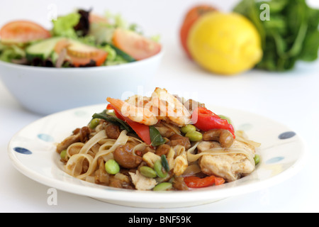 Autentico stile Thailandia Street Food Stir-Fried Pad Thai Noodles con pollo e gamberi contro uno sfondo bianco con n. di persone Foto Stock