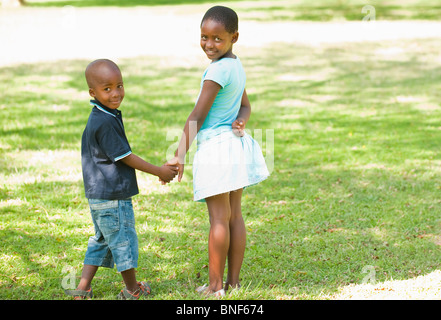 Ritratto di ragazzo e una ragazza (4-8) tenendo le mani in giardino, Johannesburg, provincia di Gauteng, Sud Africa Foto Stock