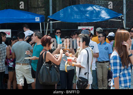 Burmese-Americans mangiare cibo tradizionale da venditori al XVI annuale acqua birmano Festival di New York Foto Stock