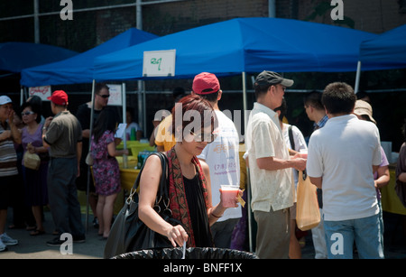 Burmese-Americans mangiare cibo tradizionale da venditori al XVI annuale acqua birmano Festival di New York Foto Stock