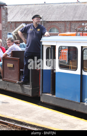 Ingegnere e i passeggeri a bordo a scartamento Ravenglass & Eskdale treno alla stazione di Ravenglass, Cumbria, Inghilterra Foto Stock