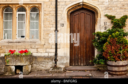 In legno antico porta anteriore e da bifore di tipico vecchio Cotswold stone house nel Wiltshire villaggio di Sherston, England, Regno Unito Foto Stock