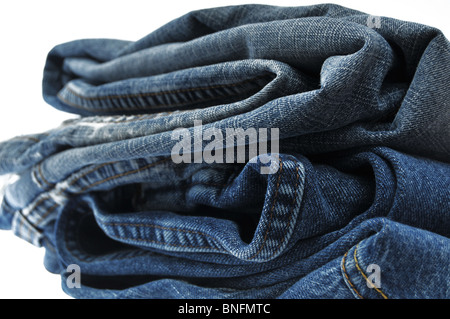 Pila di jeans blu isolato su bianco Foto Stock