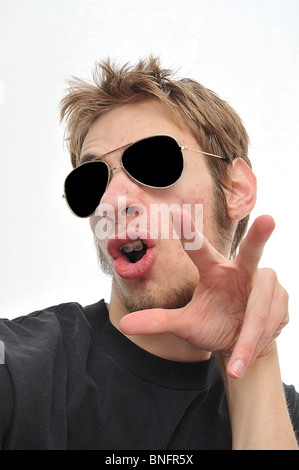Hyped up giovane adulto indossando aviatori isolati su sfondo bianco Foto Stock