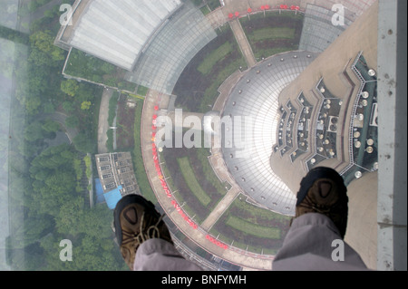 Guardando giù dal ponte di osservazione della Oriental Pearl Tower, Pudong, Shanghai, fotografo con i piedi sul ponte di vetro Foto Stock