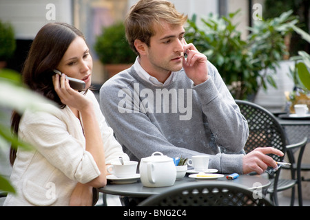 Coppia con mobili che viene ignorato al tavolo di un bar Foto Stock