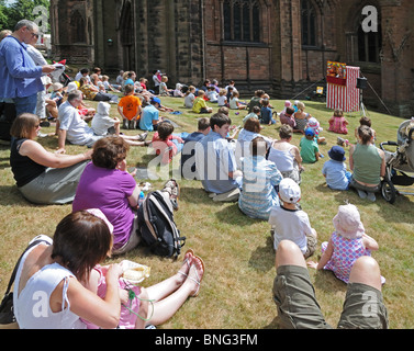 I bambini e gli adulti a guardare il punch e Judy mostrano a Lichfield Festival Market Luglio 2010 Staffordshire Inghilterra Foto Stock