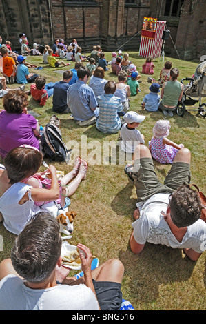 I bambini e gli adulti a guardare il punch e Judy mostrano a Lichfield Festival Market Luglio 2010 Staffordshire Inghilterra Foto Stock