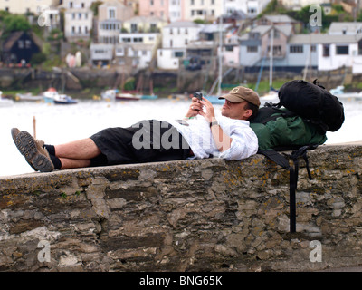 Viaggiatore texting, Fowey, Cornwall, Regno Unito Foto Stock