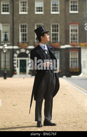 Cappello e cappotto in seta nera che trasportano un ombrello arrotolato, un dandy a Chap Olympiad, Bedford Square, Londra Inghilterra Regno Unito HOMER SYKES Foto Stock