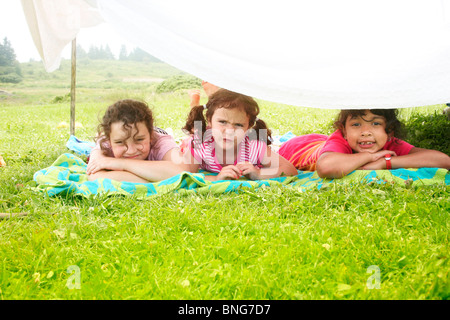 Le ragazze che giace sotto un forte fatti in casa in un prato Foto Stock