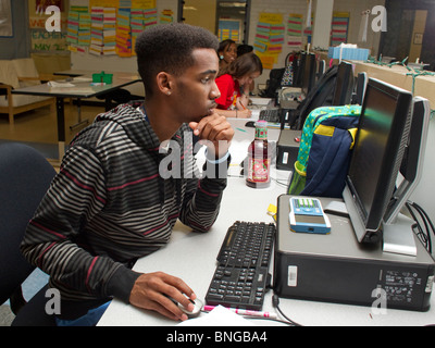 Ragazzo afro-americana funziona su computer in aula a Manor New Tech High School di Manor, Texas, Stati Uniti d'America. Foto Stock