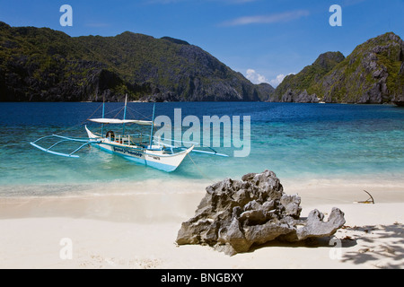 La nostra piccola barca ancorata su una spiaggia di sabbia bianca sulla MATINLOC isola nei pressi di El Nido - isola di Palawan, Filippine Foto Stock