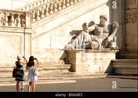 Italia, Roma, Campidoglio, Piazza del Campidoglio, turisti che scattano foto alla statua romana del Nilo Foto Stock