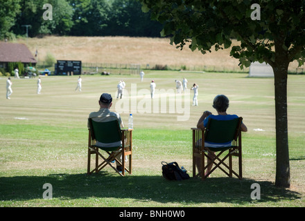 Un paio di guardare una partita di cricket di villaggio in villaggio di Lyminge vicino a Folkestone, Kent, Regno Unito Foto Stock