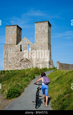 I turisti a piedi verso il castello di Reculver sul litorale di Kent. Due torri della chiesa di Santa Maria Foto Stock