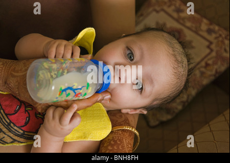 Donna alimentando il suo bambino con una bottiglia Foto Stock