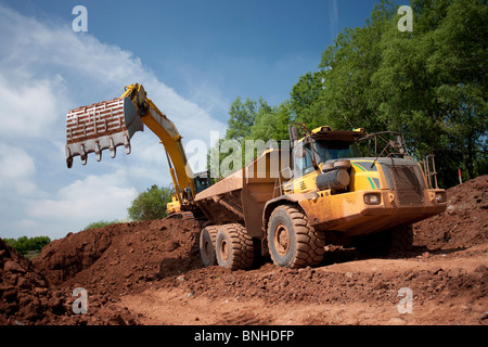 Escavatore e articolata scavatrice haul dump carrello in cava o miniera Foto Stock