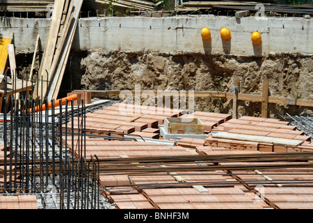 Tre costruttori testa protettivo duro cappelli sul muro sul sito di costruzione Foto Stock