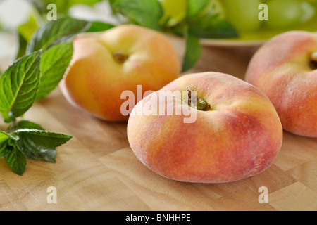 Piatto di pesche (Prunus persica var. platycarpa) Foto Stock