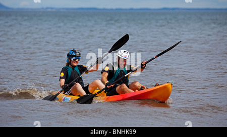 Maschio e femmina di concorrenti in gara ratto Edinburgh canoa kayak off Portobello Beach avventura estrema evento scozzese di Edimburgo Foto Stock
