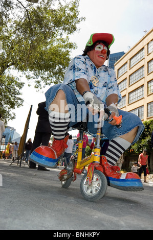 Clown in sella ad una bici in miniatura durante una parata di clown in città del Messico con i clown da diversi paesi