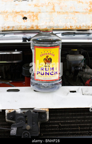Una bottiglia di rum punch tenendo in mano un cofano Foto Stock