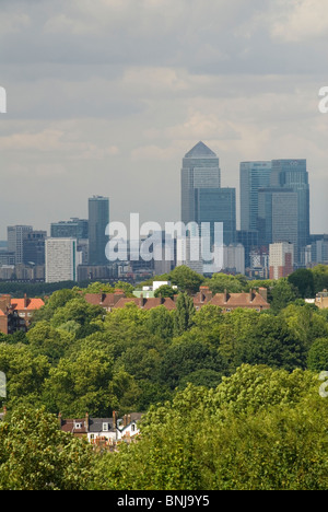 Green London, guardando in lontananza verso Canary Wharf, lo skyline della City di Londra dalla periferia sud-est di Londra, case, blocchi di alberi in primo piano. 2010 2010 UK HOMER SYKES Foto Stock