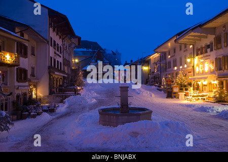 Gruyères Svizzera Canton Friburgo città piccola fontana case case illuminate Col de Pontins ILLUMINAZIONE DI NATALE Foto Stock