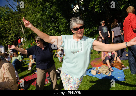 Donne di mezza età godendo il Aberystwyth Arts Center 'Mid Mad - Midsummer Madness' aria aperta free music festival, Wales UK Foto Stock