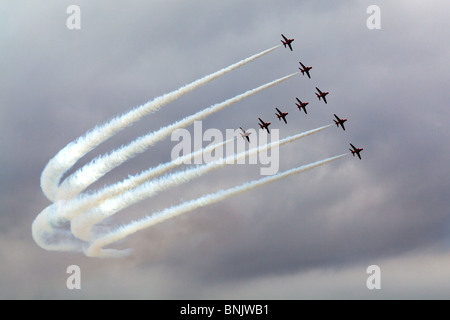 Le frecce rosse in T Formazione durante un display dell'aria con vapore bianco sentieri mostrando chiaramente contro un cielo grigio a Fairford, Gloucestershire, Regno Unito Foto Stock