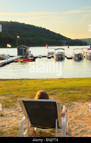 Visitatore orologi il Sun andare giù in spiaggia al Silver Tree Marina su Deep Creek Lake, Thayerville, Maryland, Stati Uniti d'America Foto Stock