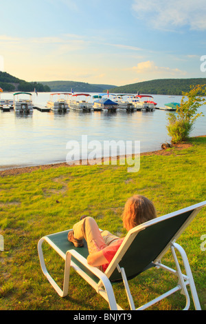 Visitatore orologi il Sun andare giù in spiaggia al Silver Tree Marina su Deep Creek Lake, Thayerville, Maryland, Stati Uniti d'America Foto Stock