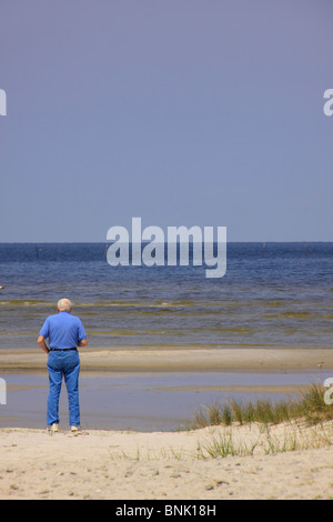 L'uomo sorge sulla spiaggia a guardare Pamlico Sound, Isola del Cedro, North Carolina, STATI UNITI D'AMERICA Foto Stock