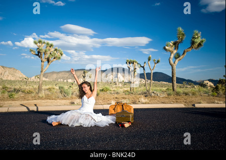 Una sposa oggetto di dumping off nel bel mezzo del nulla celebra la sua nuova libertà. Foto Stock
