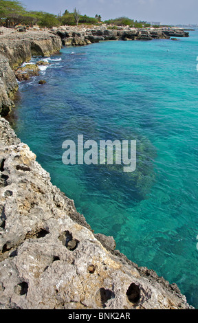 Aspre coste rocciose di Aruba con il profondo blu / verde acqua cristallina Foto Stock