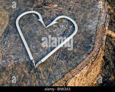 Ganci in una forma simile a un cuore, sullo sfondo di legno. Foto Stock