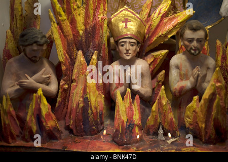 Sculture di sacerdoti e un vescovo la masterizzazione in inferno sono visualizzate in una chiesa di San Miguel De Allende, 24 novembre 2008. Foto Stock