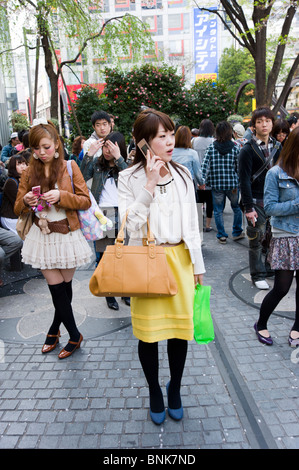 I giovani in attesa di incontrare gli amici accanto al cane Hachiko statua al di fuori della stazione di Shibuya, Tokyo, Giappone Foto Stock