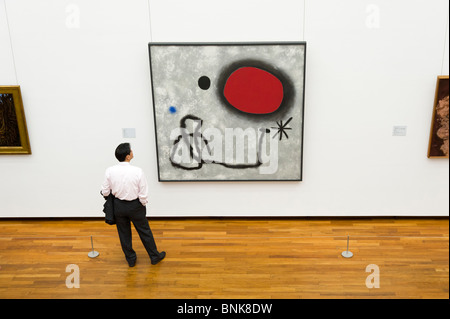 Uomo che guarda all'arte moderna pittura ad olio di Joan Miro nel Museo Nazionale di Arte Occidentale, Tokyo, Giappone Foto Stock