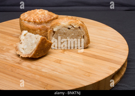 Inglese tradizionale pasticcio di carne di maiale da bassa prospettiva sul piatto di legno. Foto Stock