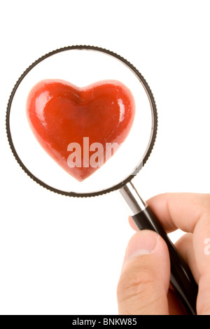 Cuore rosso con lente di ingrandimento, concetto di ricerca di amore, vita sana Foto Stock